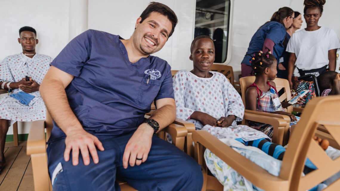 Photo of Lenny Finn with a patient on the veranda of the Mercy Ship.