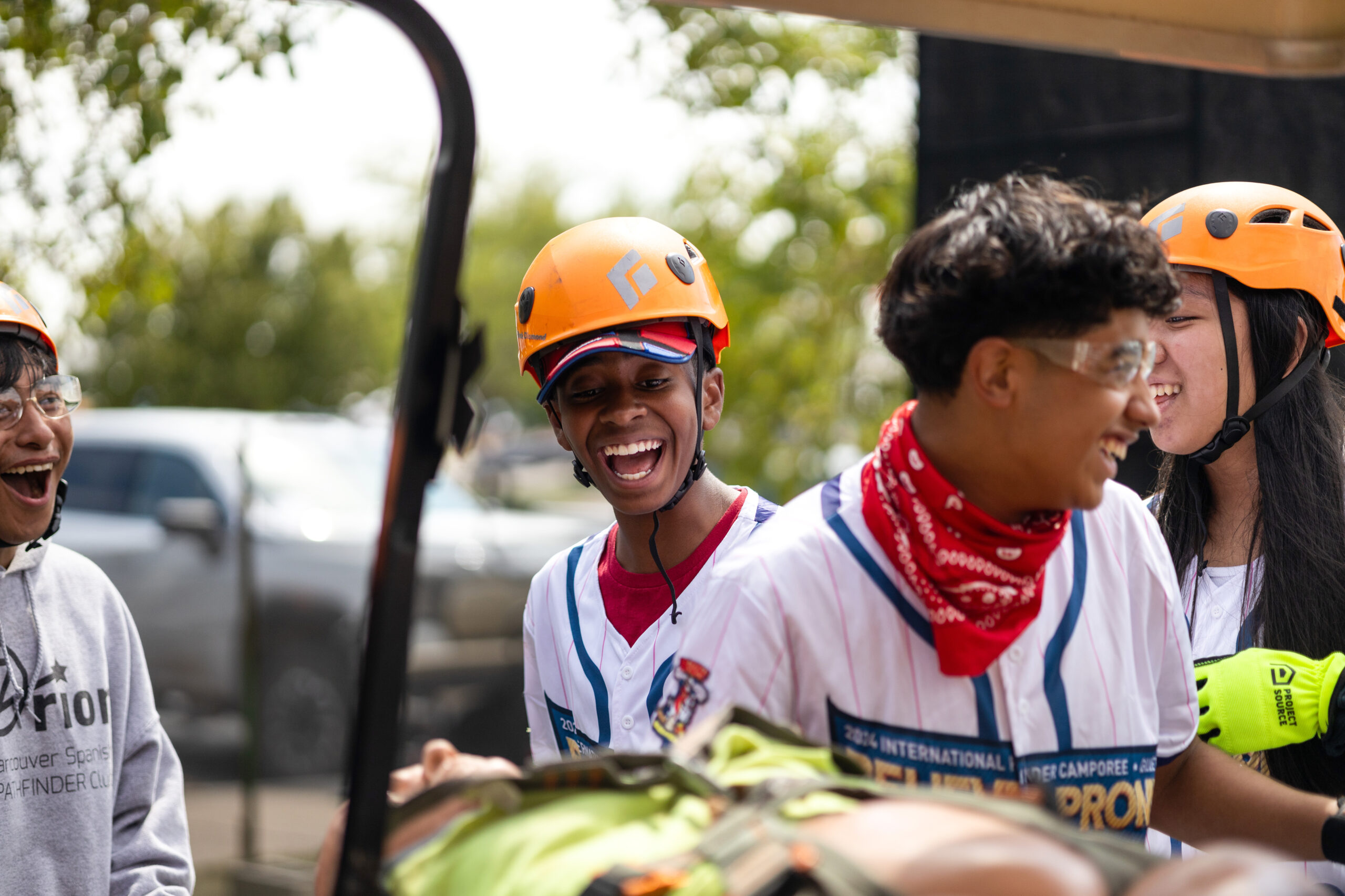 Pathfinders smile as they bring their mannequin victim on a stretcher.